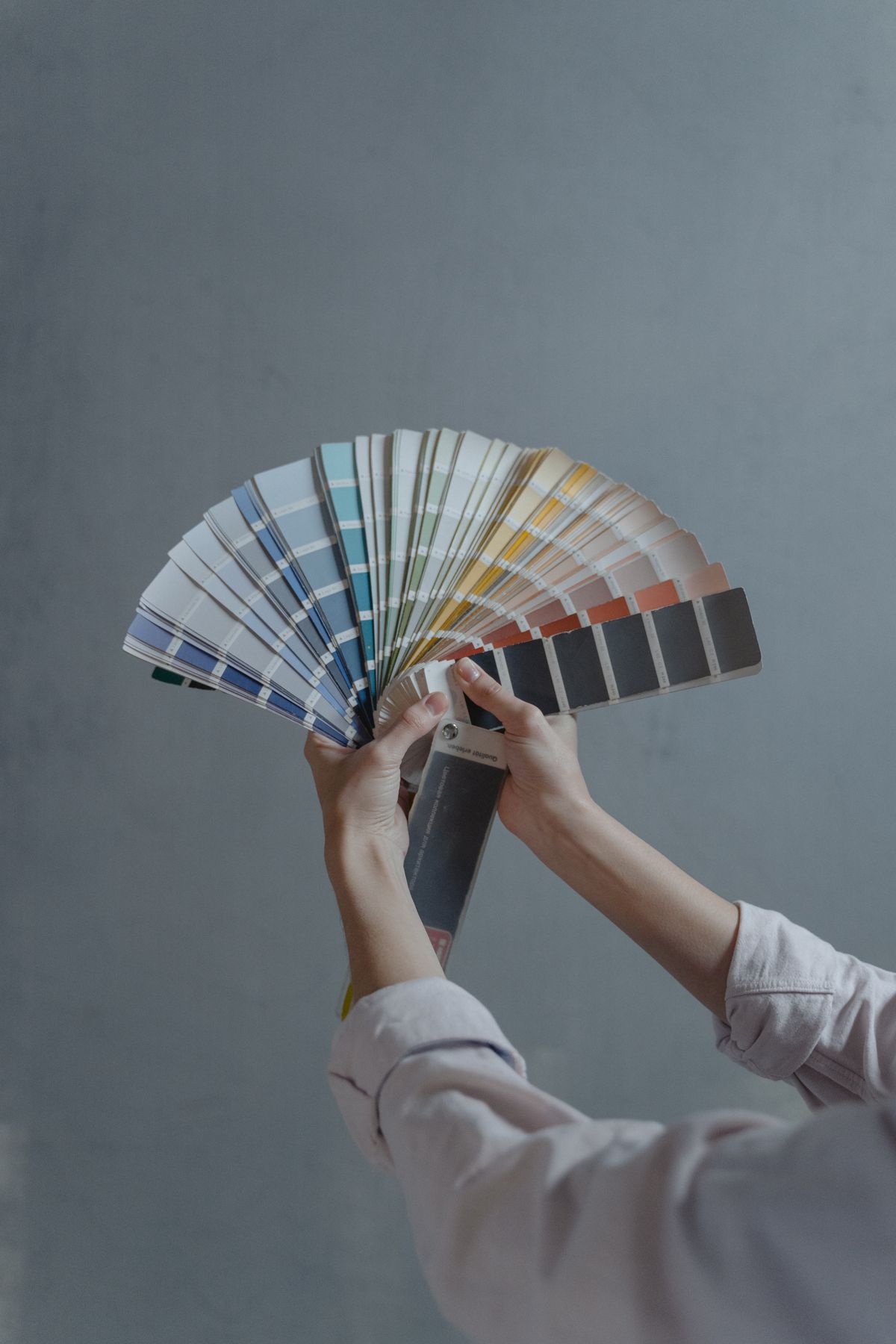 Paint colour swatches held beside a wall