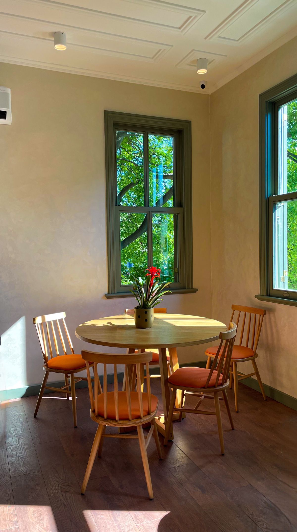 Round wooden dining table beside a window