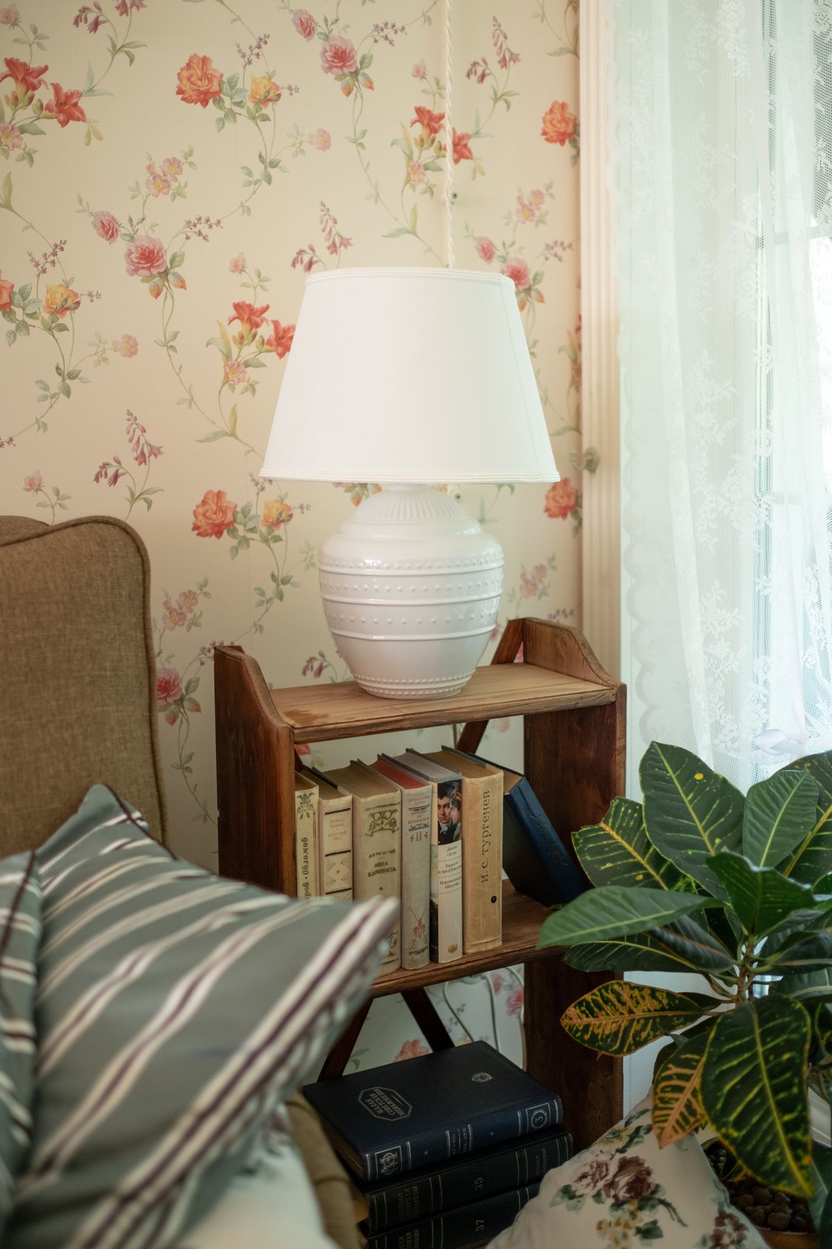 Floral wallpaper behind a small bookshelf