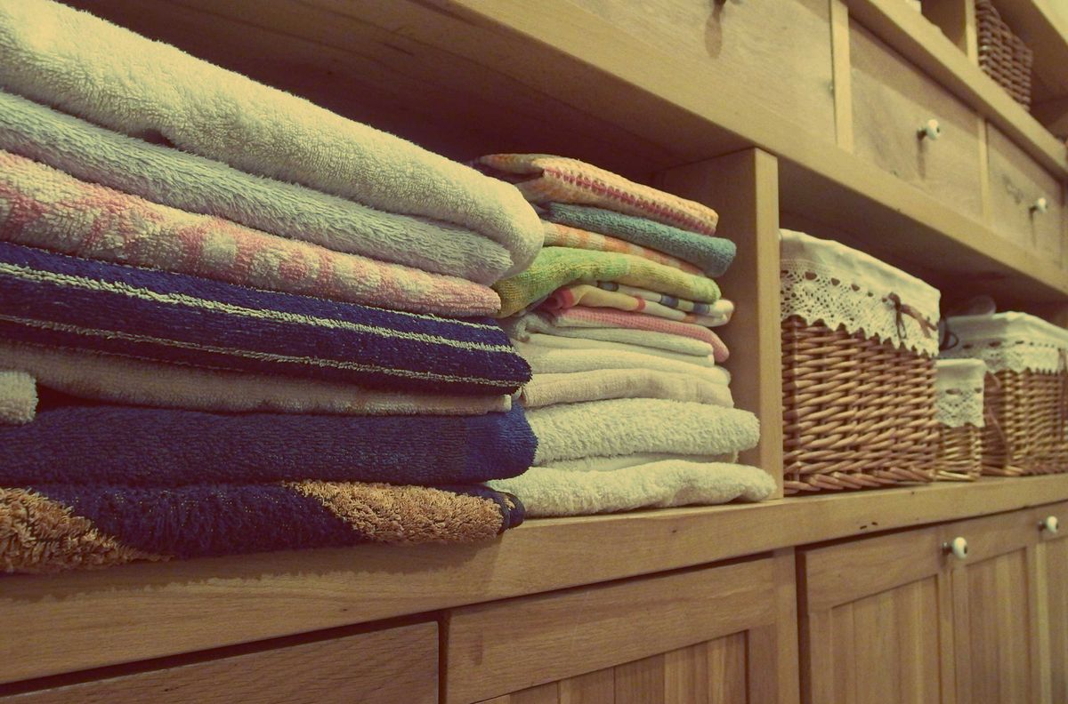 Folded towels in a cabinet with baskets