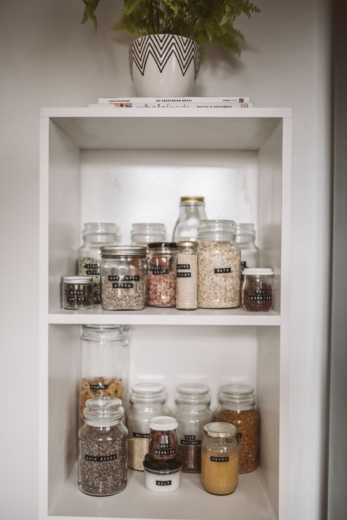 Labelled jars on white shelves
