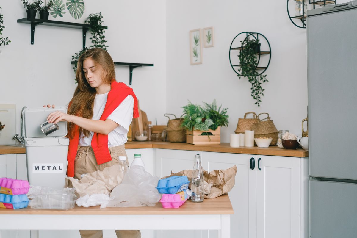 A person sorts waste in a kitchen